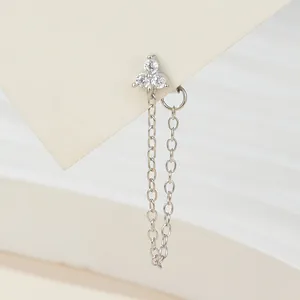 Macro detail of silver flower stud earring with sparkling crystals and tassel chain
