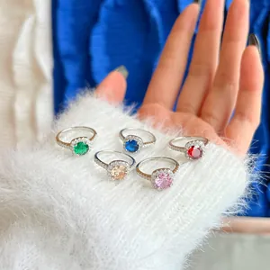 Dettaglio di cinque anelli halo scintillanti con pietre rotonde multicolori