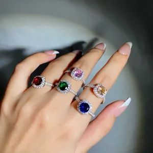 Primo piano di anelli di lusso in argento S925 con pietre di zircone colorate sulla mano