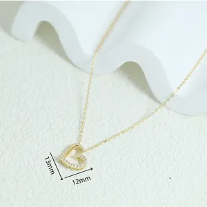 Close-up detail of a minimalist gold-plated 925 silver heart pendant necklace with stones