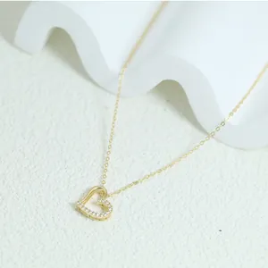Detailed close-up view of elegant golden heart-shaped pendant necklace with cubic zirconia
