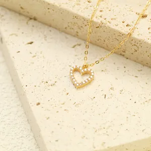 Close-up of gold heart-shaped pendant necklace with sparkling diamonds on stone