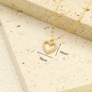 Detailed view of the 10mm pavé heart pendant necklace in gold finish on a stone surface