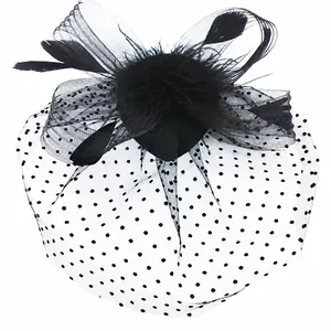 Elegant black bridal hair accessory featuring feathers and a polka dot mesh veil detail