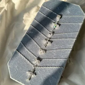 Vue détaillée de colliers en argent sterling avec pendentifs cœur et croix sur velours bleu