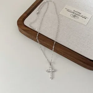 Vue détaillée d'un collier en argent S925 avec croix en zircon sur un plateau décor
