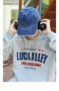 Vintage washed blue denim baseball cap shown on a model in a casual outdoor streetwear setting