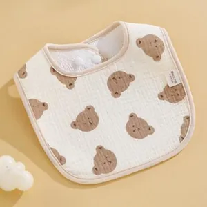 Close-up of a soft 6-layer gauze baby bib with brown bear patterns and snap buttons.