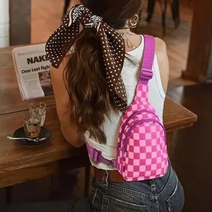 Borsa a tracolla a scacchi rosa e magenta in nylon indossata da una modella in un caffè