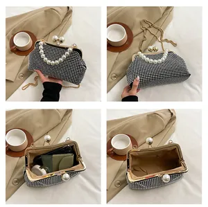Detailed view of rhinestone clutch with pearl handle and interior storage capacity.