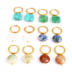 Detalle de varios pares de pendientes de aro de piedra natural con aros dorados