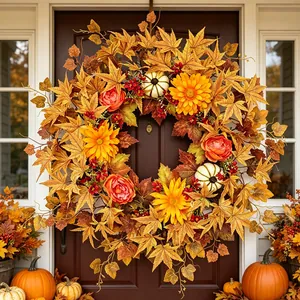 Detailed close-up of autumn wreath featuring maple leaves and mini pumpkins on a front door.