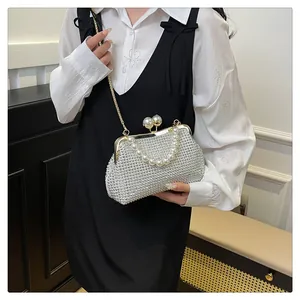 Detail view of a sparkling rhinestone evening clutch with pearl handle and chain strap