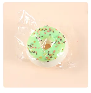 Close-up view of a realistic PU simulated green glazed doughnut model wrapped in plastic