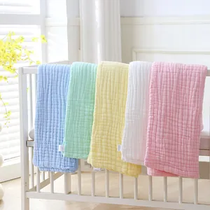 Detailed view of five colorful 110x110cm multi-layer cotton gauze baby blankets on a crib