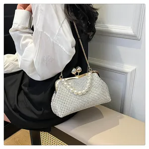 Close-up of elegant pearl handle shell bag with rhinestones carried by a model.