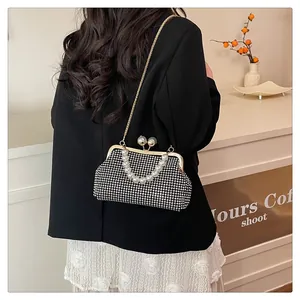 View of elegant black rhinestone evening bag with pearl handle and gold chain strap