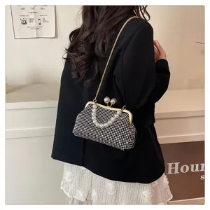 Elegant black rhinestone shell bag with pearl handle worn by model as crossbody bag.