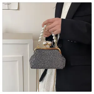 Detail view of rhinestone clutch bag with elegant oversized pearl handle and gold chain