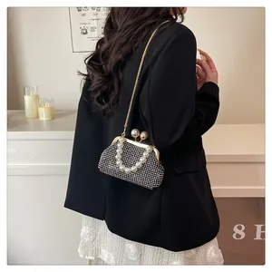 Elegant black rhinestone clutch bag with pearl handle and gold chain strap
