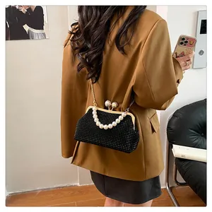 Detailed view of a black rhinestone evening bag featuring an elegant pearl handle and shell clasp.