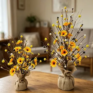 Arbre de marguerites et baies artificielles avec base en toile de jute sur table.