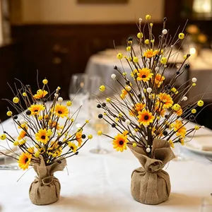 Détail de mini arbres de fleurs et baies artificielles avec base en toile de jute
