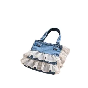 Detailed view of a washed denim tote bag featuring elegant double white ruffle trim