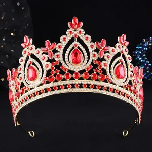 Nahaufnahme einer goldenen Barock-Brautkrone, verziert mit funkelnden roten und weißen Kristallen.