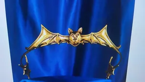Detailed view of a golden alloy bat wing headband for Halloween vampire costumes.