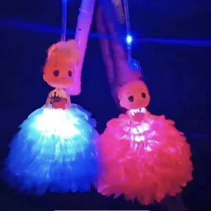 Pareja de farolillos de muñeca con luces LED y faldas de tul rosa y azul en la oscuridad