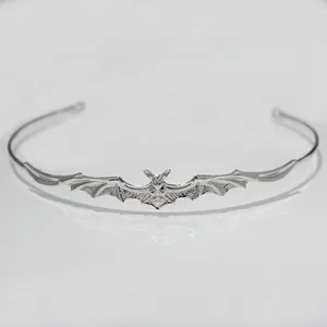 Detailed macro shot of gothic silver bat tiara featuring intricate baroque wing designs