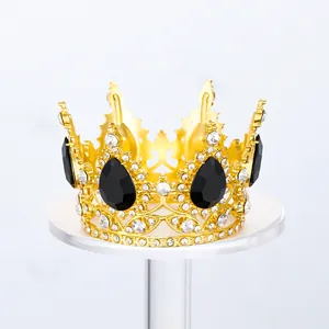 Detalle de una corona de aleación dorada con pedrería negra para decoración de pasteles