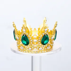 Detalle de una corona dorada con cristales verdes para decoración de pasteles.