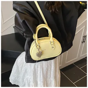 Stilvolle kleine gelbe Bowling-Handtasche aus genarbtem Leder mit einem Herzanhänger