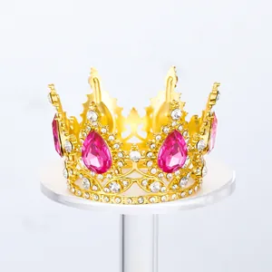 Vista detallada de corona dorada con diamantes de imitación rosas en soporte blanco