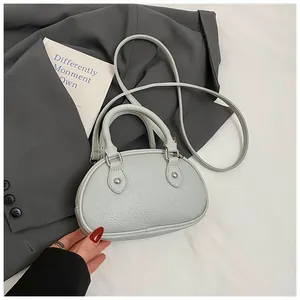 Detailansicht einer grauen Muschel-Handtasche mit Lychee-Maserung und Silbernieten