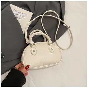 Nahaufnahme der cremefarbenen Bowling-Handtasche mit eleganter Kieselleder-Struktur