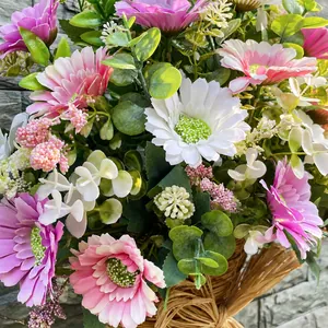 Détail d'un panier de fleurs artificielles marguerite et eucalyptus pour décor de porte