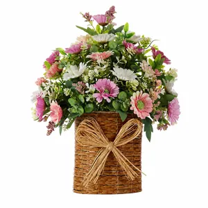 Détail de marguerites et eucalyptus artificiels dans un panier en paille avec nœud