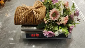 Panier de fleurs artificielles avec marguerites roses pesé sur balance à 0,37kg