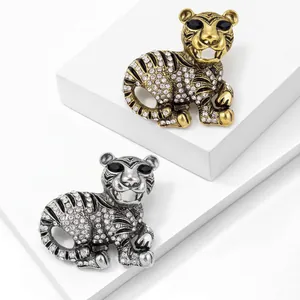 Detailed macro shot of gold and silver tiger brooches with sparkling crystal rhinestones.