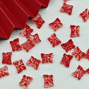 Detailed macro view of red glass butterfly beads for DIY jewelry with size markings.