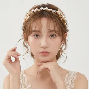 Elegant gold leaf bridal headband decorated with pearls and rhinestones on female model