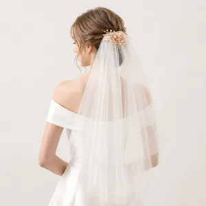 Detailed view of an elegant double-layer tulle wedding veil with pearl flower comb