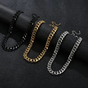 Detail view of black, gold, and silver stainless steel Cuban link necklaces on black background.