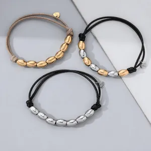 Detailed view of stainless steel oval beads on adjustable black and tan woven cord bracelets