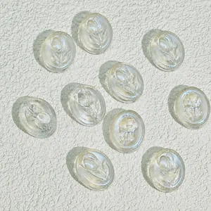 Detailed close-up of oval transparent glass beads featuring embossed floral tulip patterns