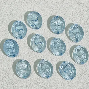 Macro view of blue oval glass beads with detailed rose pattern engraving
