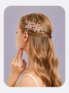 Close-up of elegant floral bridal hair comb with rhinestones and pink petals